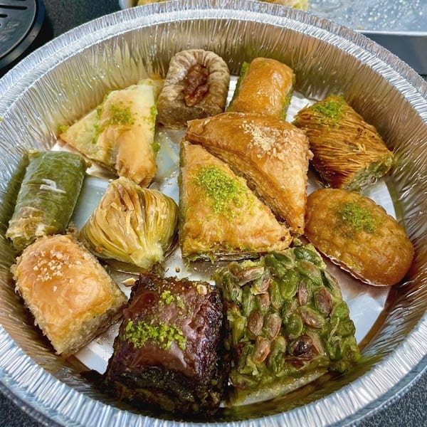 Assortment of baklava and other Turkish desserts in a foil container from Kapadokia Grill.