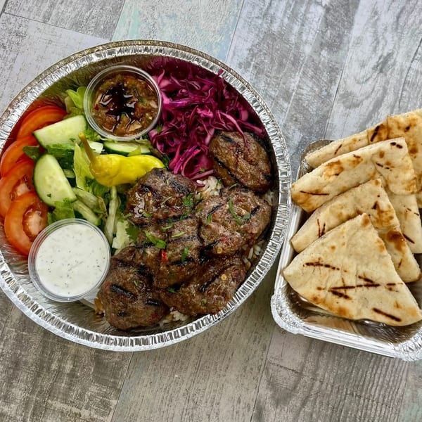 Kapadokia Grill's Mediterranean Turkish meal with grilled meatballs, rice, salad, sauces, and pita bread.