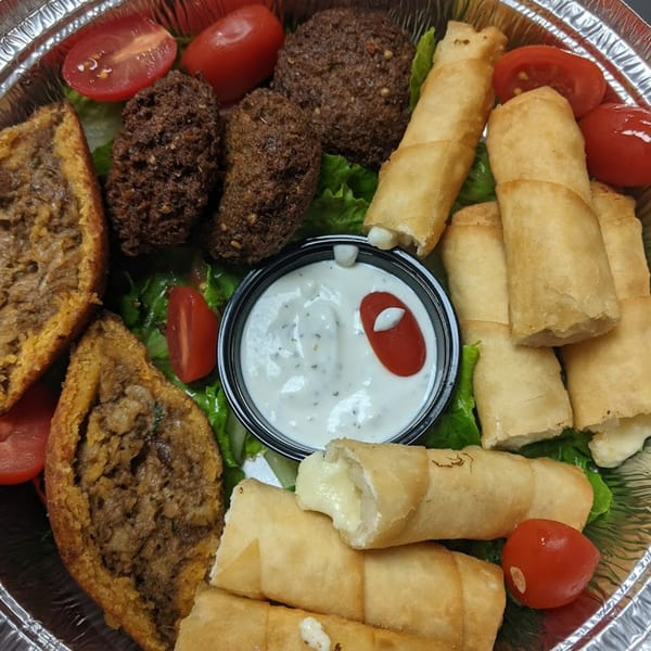 Kapadokia Grill's appetizer platter with falafel, kibbeh, cheese rolls, tomatoes, lettuce, and dipping sauce.