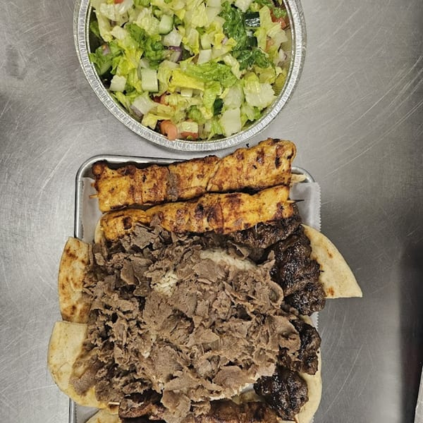 Overhead view of a Kapadokia Grill platter with chicken and beef kebabs, gyro meat, and a side salad.